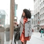 Elegancka kobieta w płaszczu przegląda wystawę sklepową w mieście