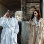 Kobieta w beżowym płaszczu obok koleżanki w szlafroku przy ceglanej ścianie