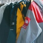 Kolorowe kurtki Supreme z poliestru wiszące na wieszaku w sklepie