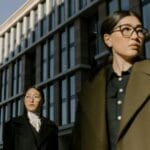 Dwie Azjatki w modnych płaszczach dwurzędowych na miejskim spacerze