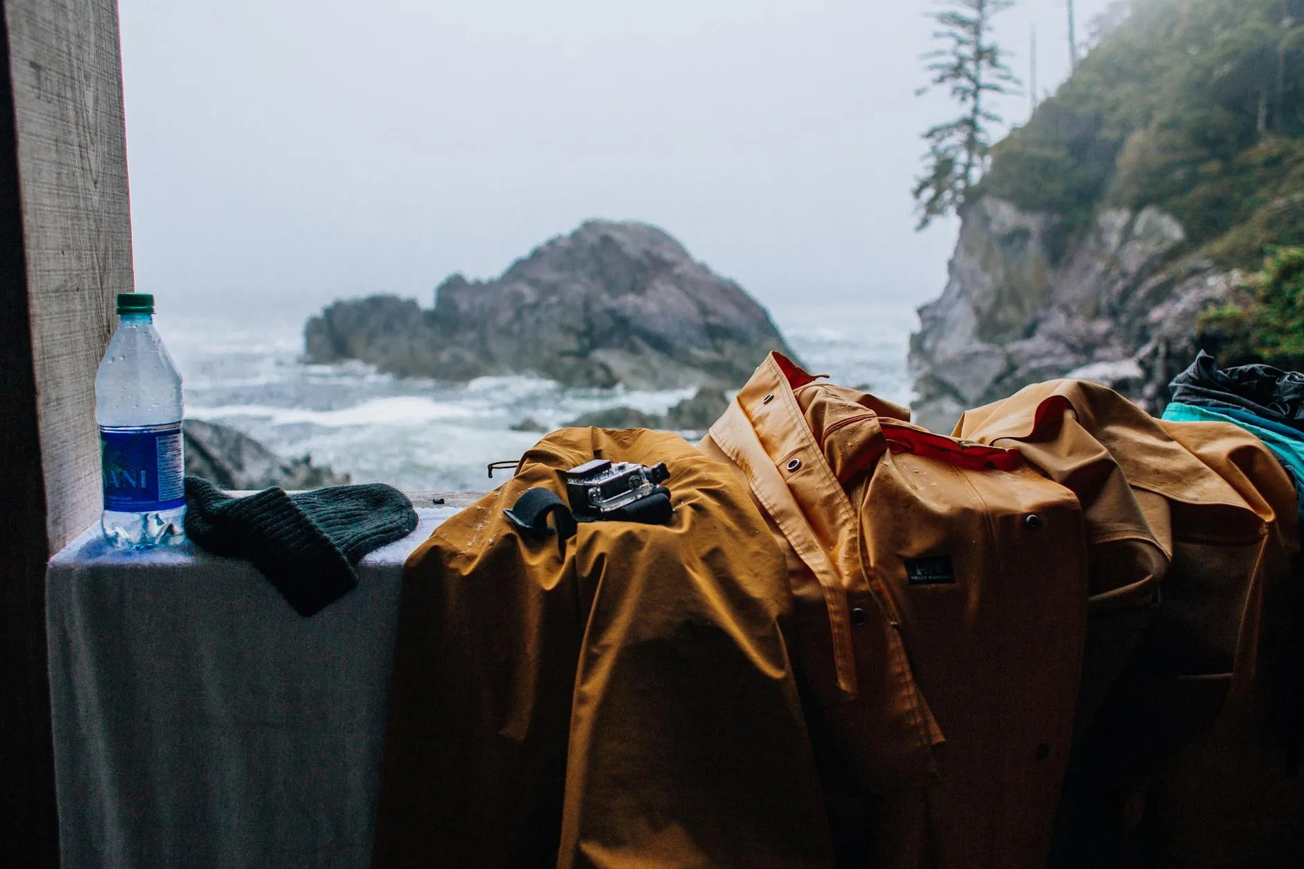 Jakie materiały kurtek są naprawdę wodoodporne, a które tylko udają ochronę Kurtka outdoor i plecak z ekwipunkiem na skalistym wybrzeżu