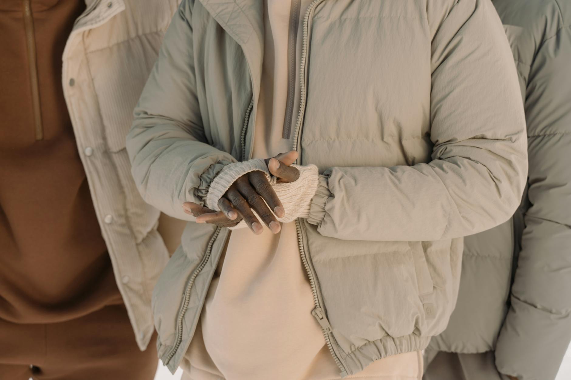 Jak komponować zimowe stylizacje warstwowe, żeby wyglądać lekko i modnie, a jednocześnie nie marznąć Zbliżenie różnych osób w pikowanych kurtkach i zimowych warstwach ubrania